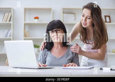 Daughter explaining to mom how to use computer Stock Photo