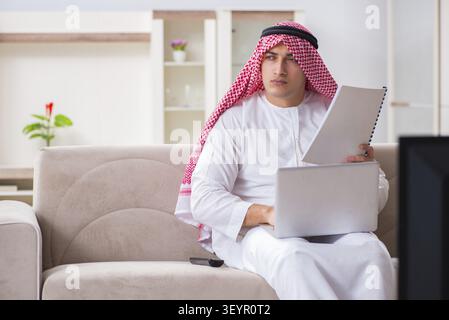 Arab businessman watching tv at home Stock Photo