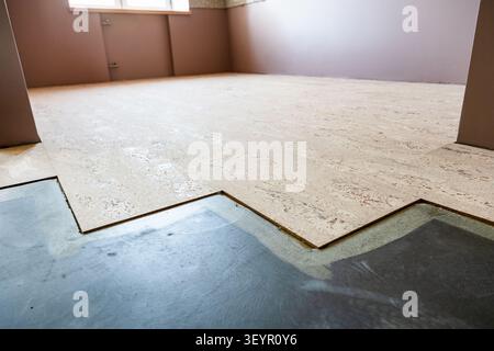 cork flooring tiles glued to concrete base in home close-up Stock Photo