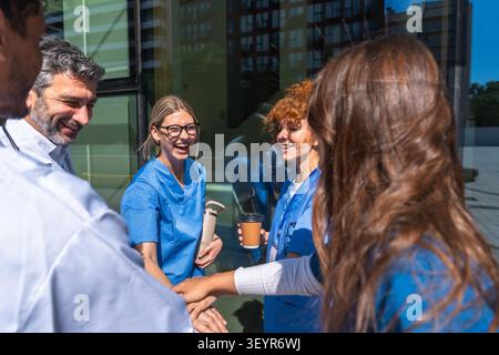 Medical team collaborating and stacking hands outdoors Stock Photo