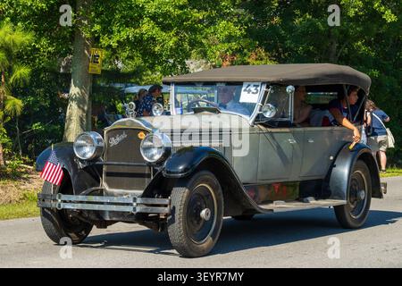 Lynn Haven, FL, USA. 4th Jul 2026. An antique Packard touring car, entry No. 43, its patinated hood and Cormorant mascot showing decades of age and a small American flag on the front bumper, carries a driver in a bow tie and passengers along the route during the city's annual Fourth of July parade. The morning procession opens Freedom by the Bay, marking America's 250th birthday, and continues into an evening at A.L. Kinsaul Park on North Bay with live music from Taydee Marie and The Band Waleska, food trucks and fireworks after sunset. Credit: Tosh Persons / Ģ����ý Live News Stock Photo