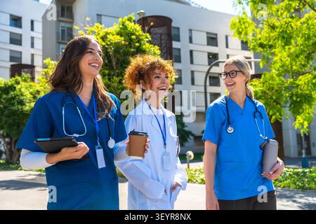 Diverse group of female medical professionals collaborating outdoors Stock Photo
