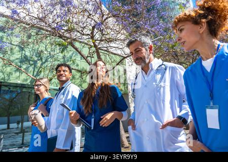 Diverse medical team walking together in healthcare discussion Stock Photo