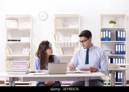 Male lecturer giving lecture to female student Stock Photo