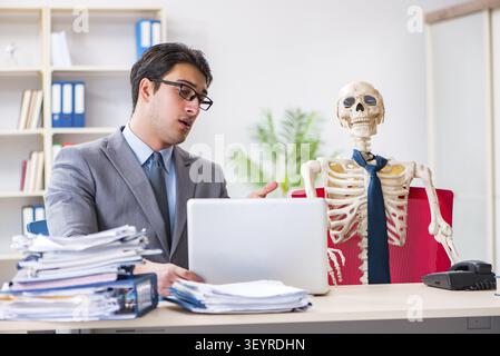 Businessman working with skeleton in office Stock Photo