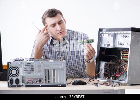 Young technician repairing computer in workshop Stock Photo