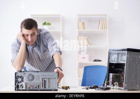 Young technician repairing computer in workshop Stock Photo