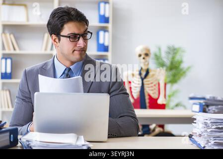 Businessman working with skeleton in office Stock Photo