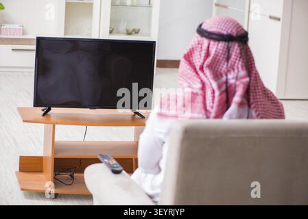 Arab businessman watching tv at home Stock Photo