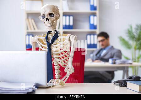 Businessman working with skeleton in office Stock Photo
