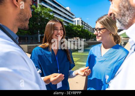Healthcare professionals discussing outdoors, sharing expertise and teamwork Stock Photo