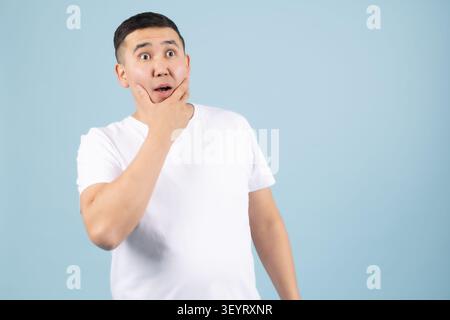 Young man touching his chin with a thoughtful expression on face Stock Photo