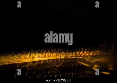 Dynamic dual light trail composition featuring vibrant white waves and gold blur. Stock Photo