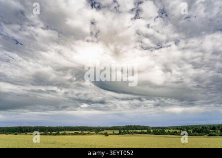 Beautiful textured cloud formations stretching across the sky above a peaceful rural landscape Stock Photo