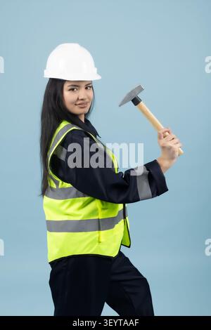 Female construction worker holding a manual hammer for repair work Stock Photo