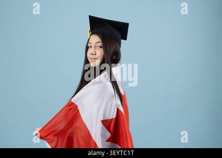 Proud graduate student holding a national flag to celebrate degree Stock Photo