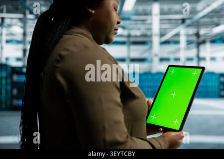 Data center engineer works with a chroma key tablet, using an editable screen to review performance data. Stock Photo