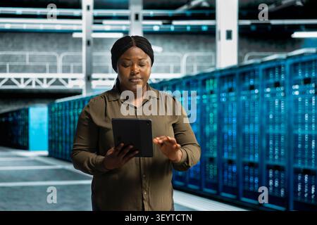 Data center engineer uses a desktop computer in a data center to support failure detection and reliable server workflows. Stock Photo