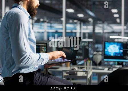 Data center programmer reviews artificial intelligence systems and machine learning processes inside a data center. Stock Photo