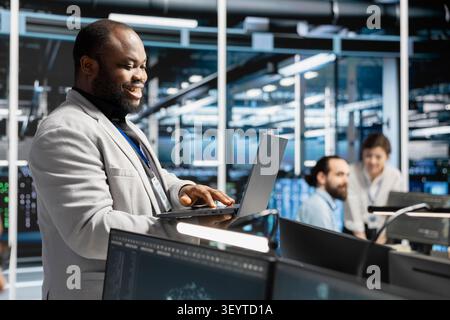 Pleased data center administrator celebrates a successful server software update in a data center. Stock Photo