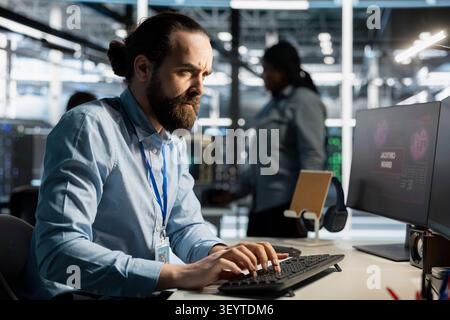 Worried server room technician reviews a diagnostic report about critical hardware malfunction and uptime risk. Stock Photo