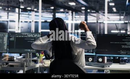 Server room manager checking work done by admins working with deep learning to review data sets. Stock Photo