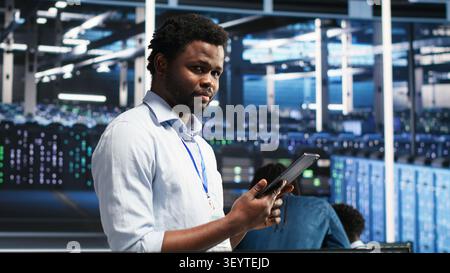 Data center technician uses node tree software to identify equipment performance issues and data patterns. Stock Photo