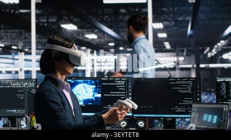 Data center engineer uses a VR headset to review AI diagnostics and manage server system performance. Stock Photo