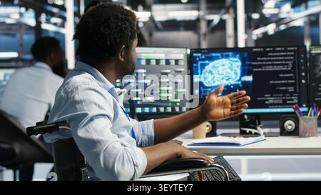 Man in wheelchair dissatisfied with data center AI analytics metrics. Stock Photo