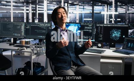 Smiling server room manager filming presentation, showcasing equipment working with AI tech. Stock Photo
