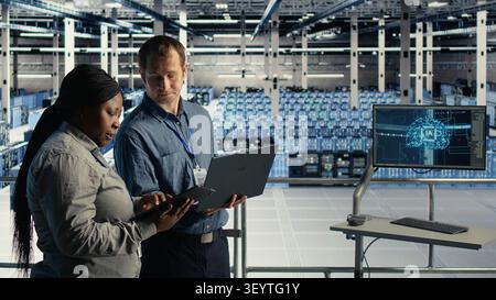 Data center engineering team manages software updates in a server room to keep data center systems stable. Stock Photo