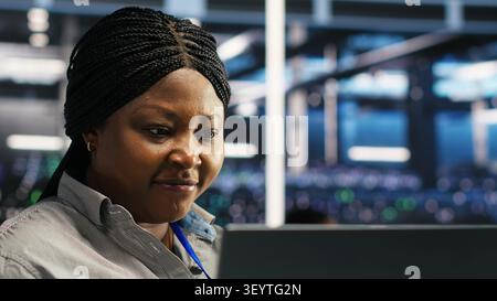 System administrator works through node tree software problems while analyzing AI infrastructure in a data center. Stock Photo