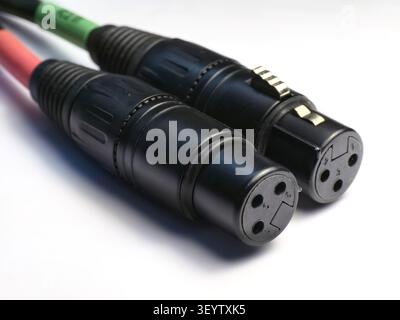 Two black xlr female connectors with colored cables against a clean white background Stock Photo