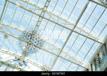 Abstract view of a modern building's glass ceiling featuring a dynamic skylight. Contemporary architectural design highlighting structural elegance an Stock Photo