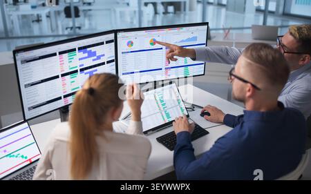 Team Of Medical Billing Analysts Coding And Reviewing Spreadsheets Together. Stock Photo