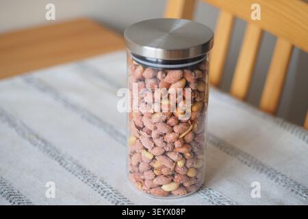 Container holds peanuts on a table in a kitchen Stock Photo