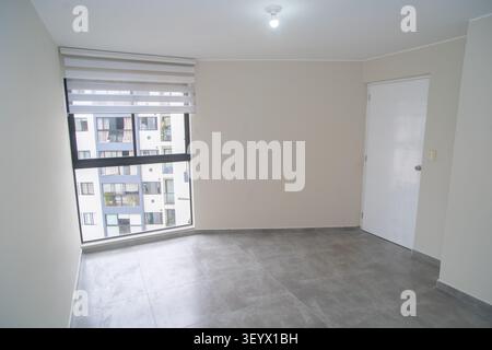 Empty modern room with grey tiled floor, window blinds, and city view background Stock Photo