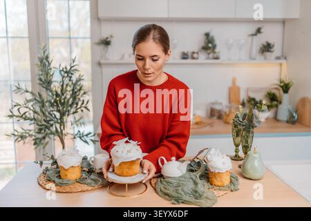 Easter cake woman kitchen preparing traditional kulich for spring holiday table setting Stock Photo