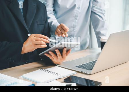 Business professionals using tablet and laptop for digital financial planning, showing accounting technology, online report review and corporate colla Stock Photo