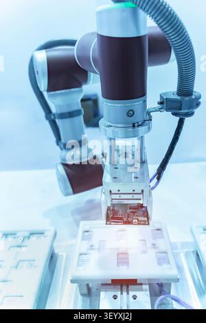 automatic robot for print circuit board (PCB)assembly machine during soldering or welding part at factory Stock Photo