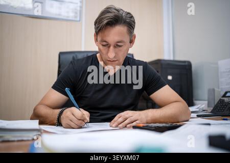 Office manager signing important documents at desk. Boss putting signature on paperwork. Stock Photo