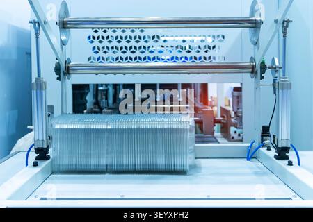 Stack of polypropylene food containers on conveyor belt of automatic plastic injection molding machine,automated technology concept Stock Photo