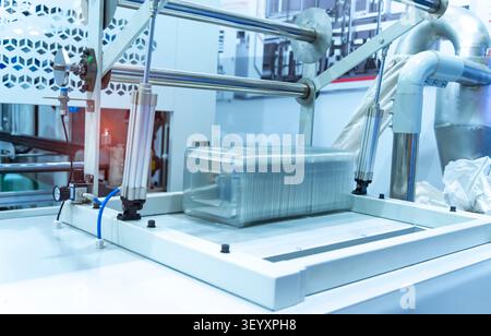Stack of polypropylene food containers on conveyor belt of automatic plastic injection molding machine,automated technology concept Stock Photo