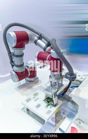 automatic robot for print circuit board (PCB)assembly machine during soldering or welding part at factory Stock Photo