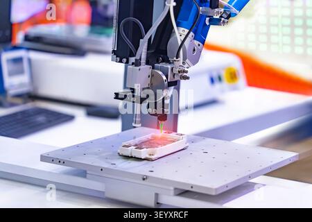 Robot holding glue syringe Injection and assembly pcb board Stock Photo