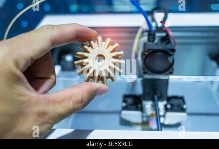 hand with Object of gear printed on 3d printer close-up Stock Photo
