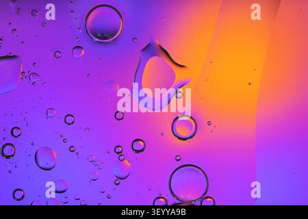 Oil and water creating vibrant purple and orange abstract bubbles Stock Photo