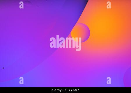Oil bubbles creating an abstract purple and orange gradient texture background Stock Photo