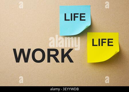 Work-life balance. Paper notes on dark beige background, top view Stock Photo