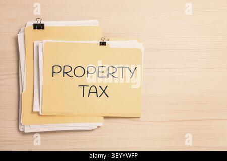 Property tax. Folders with documents on wooden table, top view. Space for text Stock Photo